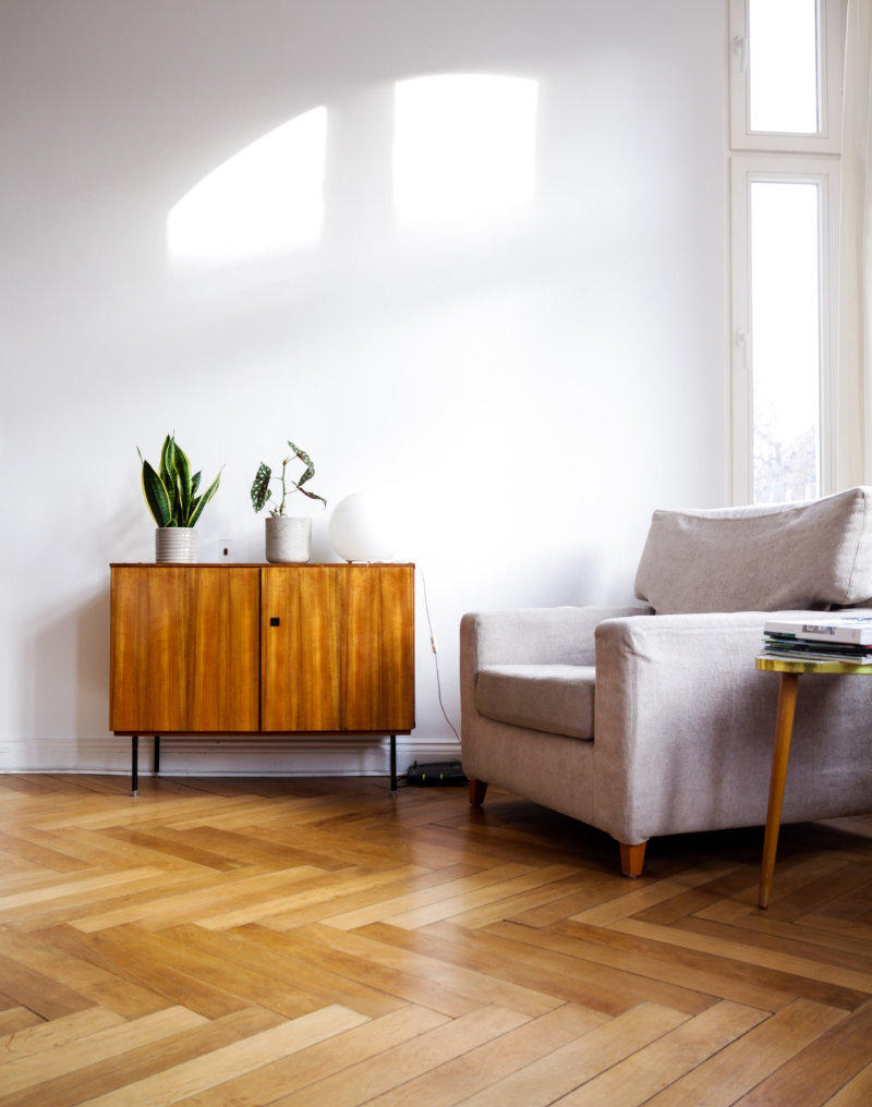 shiny hardwood floor with a sitting chair sitting in the corner of a room